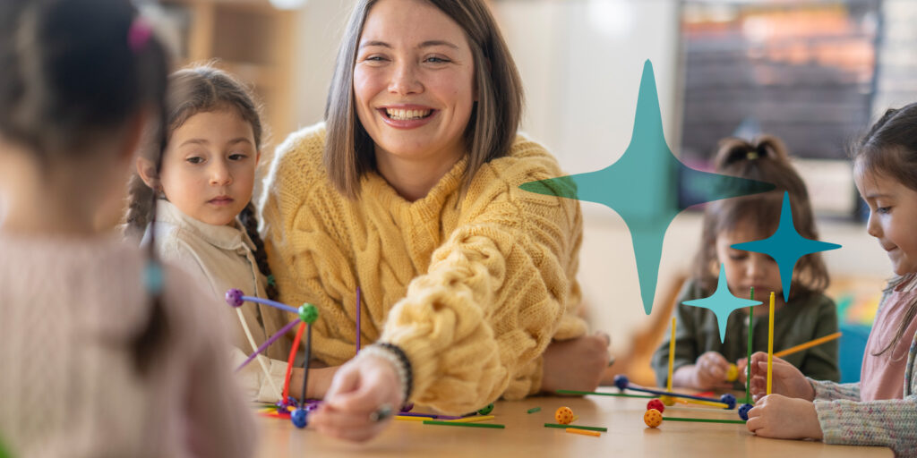 Junge Frau mit Kindern an einem Tisch beim Spielen.